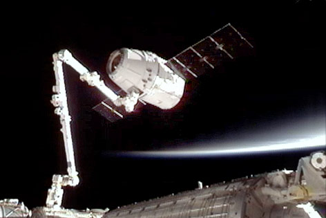© AP/NASA Der Raumtransporter „Dragon“ dockt an dem Arm der Internationalen Raumstation (ISS) an