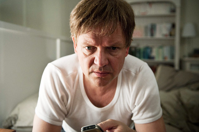 © Filmverleih/Little Shark/Martin Menke Joachim Ebling (Justus von Dohnányi) sitzt auf seinem Bett mit dem Mobiltelefon in der Hand