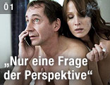 Nackter Mann telefoniert am Handy während eine nackte Frau auf seinem Rücken anlehnt