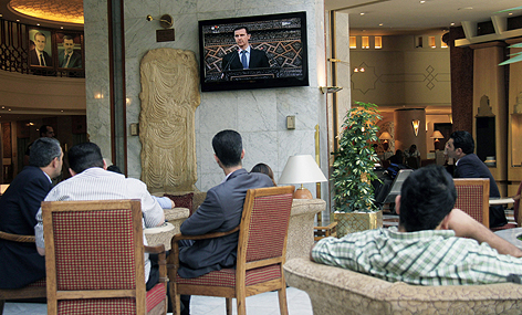 Menschen verfolgen Assad-Rede im TV