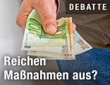 Hand reicht Geldscheine
