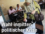 Frau gibt bei ägyptischer Wahl ihren Stimmzettel ab