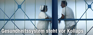 Eine griechische Krankenschwester steht neben einem Krankenhausangestellten