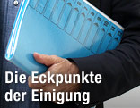 Mann hält Aktenordner