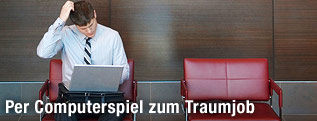 Mann mit Laptop kratzt sich am Kopf
