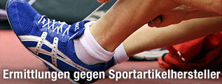 Leichtathlet bindet sich seine Asics-Laufschuhe