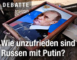 Ein Bild von Wladimir Putin liegt auf einem M&uuml;llhaufen