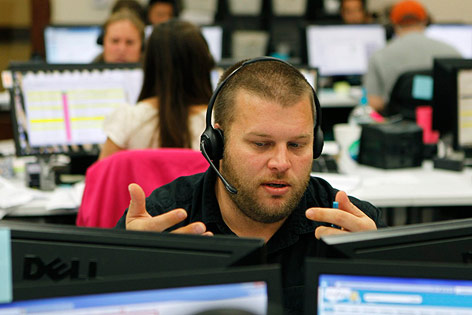 © Corbis/Erich Schlegel Arbeiter mit Headphone an einem Computer in einem Großraumbüro