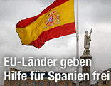 Eine spanische Fahne vor der Columbus-Statue in Madrid
