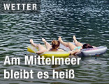 Zwei Junge Frauen schwimmen mit einer Luftmatraze im See