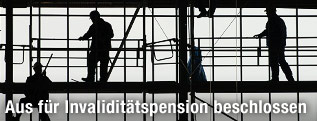 Bauarbeiter auf einem Gerüst im Gegenlicht