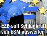 Frau geht mit Euro-Rettungsschirm vor der Europäischen Zentralbank