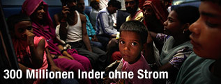 Familien sitzen mit ihren Kindern im Dunklen
