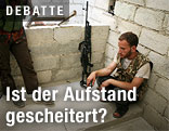 Syrischer Rebelle am Boden hockend
