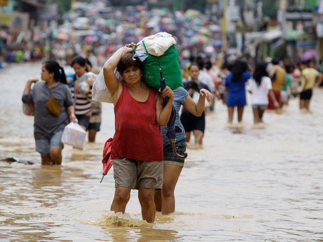 © AP/Aaron Favila Menschen auf überfluteter Straße im Osten von Manila