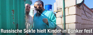 Zwei Mitglieder einer russischen Untergrundsekte am Eingang ihres Anwesens