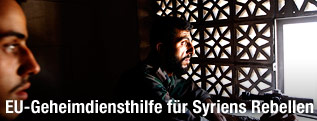 Syrische Rebellen blicken aus einem Fenster