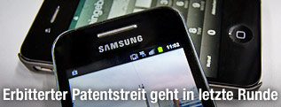 Ein Samsung-Smartphone liegt auf einem iPhone von Apple