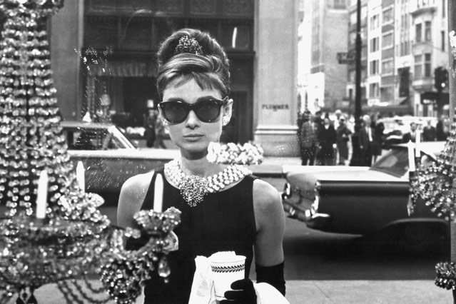© Corbis/Everett Collection Audrey Hepburn steht im Film "Frückstück bei Tiffanys" mit einer Sonnenbrille vor einem Schaufenster (1961)