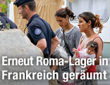 Zwei Frauen mit Kleinkind werden von zwei Polizisten von ihrem Wohnwagen abgef&uuml;hrt