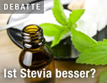 Steviakonzentrat in der Flasche neben Würfelzucker und Blätter der Stevia-Pflanze