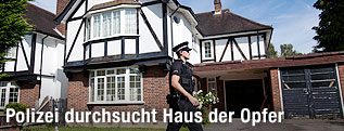 Polizist vor dem Haus des Opfers