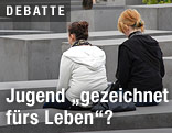 Jugendliche sitzen auf einer Parkbank