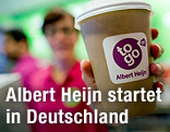 Angestellte des Minimarktes "Albert Heijn to go" mit Kaffeebecher