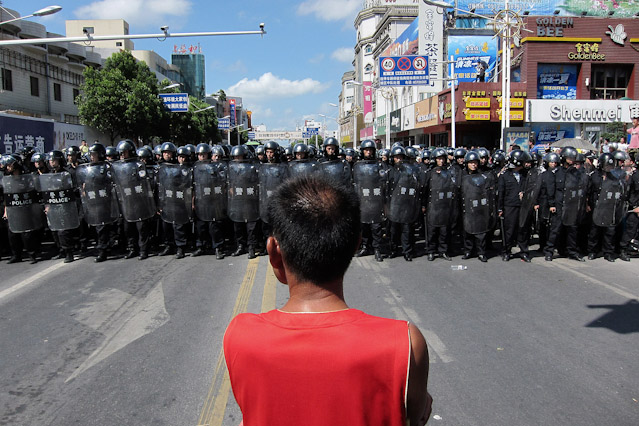© AP/ Eugene Hoshiko Demonstrant steht vor Mauer aus Sicherheitskräften