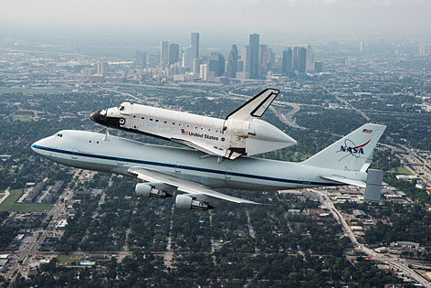 © Reuters/NASA/Sheir Locke "Endeavour" auf dem letzten Flug über Houston am Rücken eines NASA-Flugzeuges, im Hintergrund Skyline von Houston