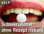 Frau hält eine Tablette zwischen den Zähnen