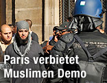 Polizisten versperren einem Demonstranten in Paris den Weg