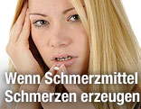 Frau mit Kopfschmerzen schluckt Tablette