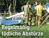 Einsatzkräfte stehen neben abgestürztem Segelflugzeug in Zell am See, 2011