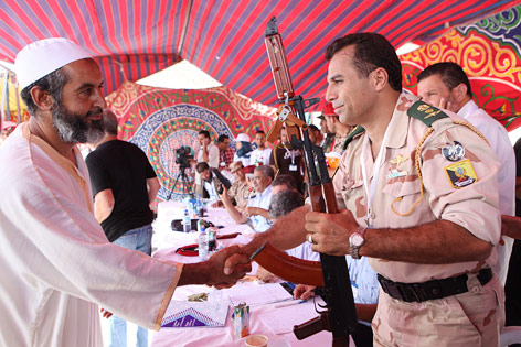 Ein Libyer übergibt seine Waffe