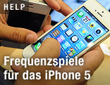 Eine Hand h&auml;lt ein iPhone 5