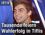 Lächelnder Anhänger der georgischen Opposition mit Flagge