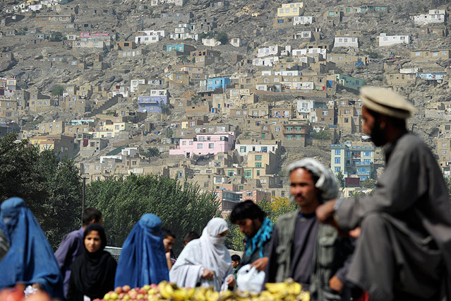 © picturedesk.com/AFP/Roberto Schmidt Bewohner von Kabul vor einem Hügel mit einfachen Häusern