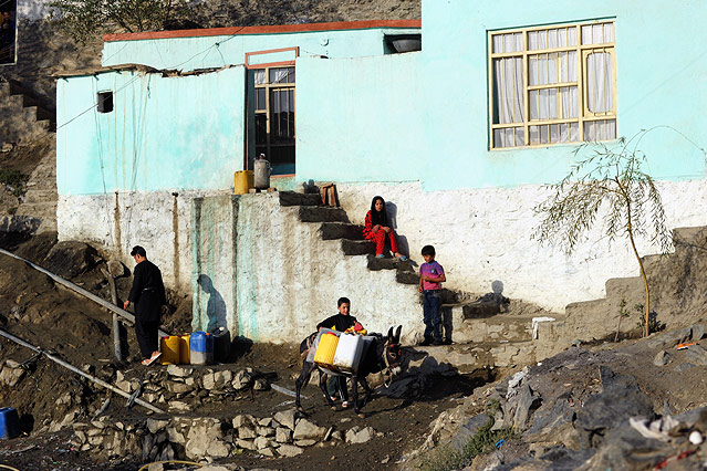 © picturedesk.com/AFP/Roberto Schmidt Kinder mit einem Esel vor einem einfachen Haus in Kabul