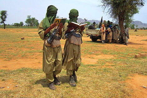 © AP/Baba Ahmed Zwei vermummte, malische Kindersoldaten mit Koran