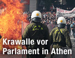 Flammen vor Einsatzkräften des Sonderkommandos, dahinter Demonstranten