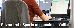 Person sitzt vor Computerbildschirm