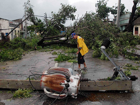 © REUTERS/Miguel Rubiera/Cuban Government National Information Agency Umgestürzte Masten und Palmen auf einer Straße in Santiago de Cuba