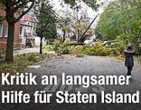 Frau steht auf einer Stra&szlig;e vor einem umgest&uuml;rzten Baum