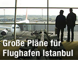 Menschen schauen durch Fenster auf Flughafen