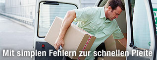 Mann lädt Pakete aus einem Auto aus