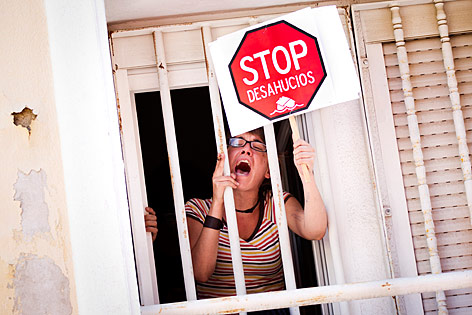 © AP/Daniel Ochoa de Olza Eine Frau protestiert mit einem Schild und lautem Schreien gegen eine Zwangsräumung