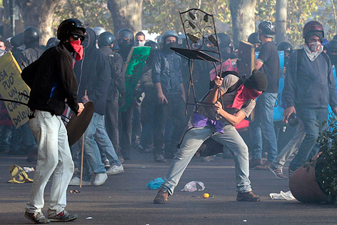 © AP/Gregorio Borgia Demonstranten werfen mit Stühlen