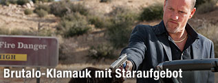 Schauspieler Woody Harrelson mit einer Waffe in einer Szene aus dem Film Seven Psychopaths