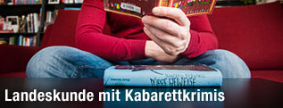 Mann hält Buch in der Hand